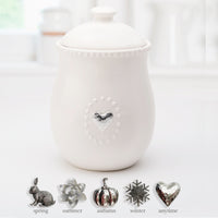 White Ceramic Canister w/Lid and  5 Interchangeable Metal Seasonal/Decor Magnets.